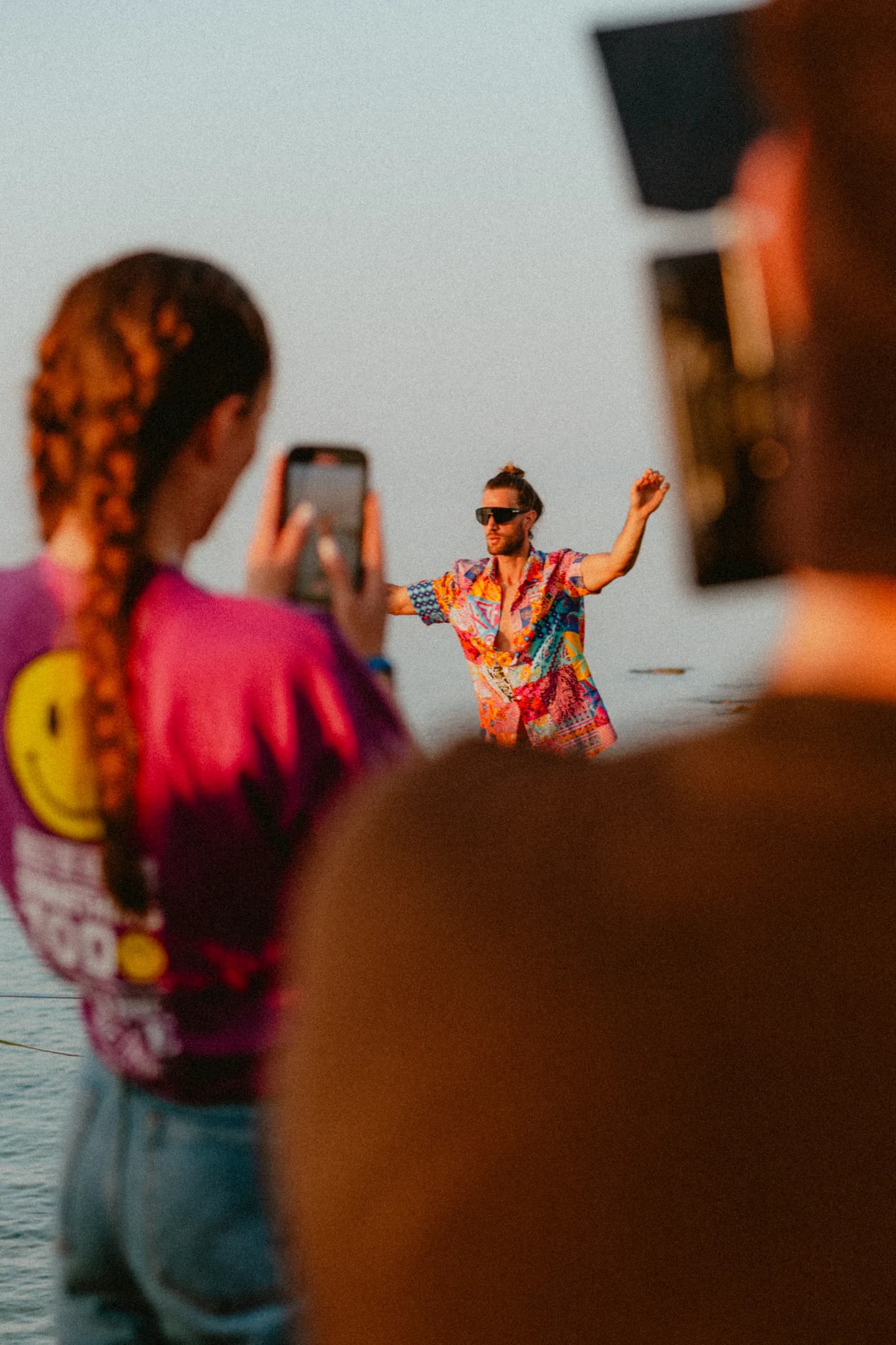Performance su una linea vicino al mare, mentre il pubblico la riprende con lo smartphone